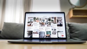 Laptop with pinterest pulled up on screen. Pinterest board shows various home decor