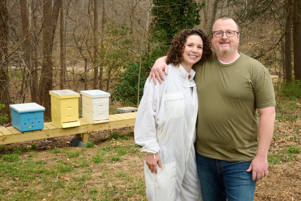 Christina and Jason Bruegger in front of their beehives in Alexandria, VA. 